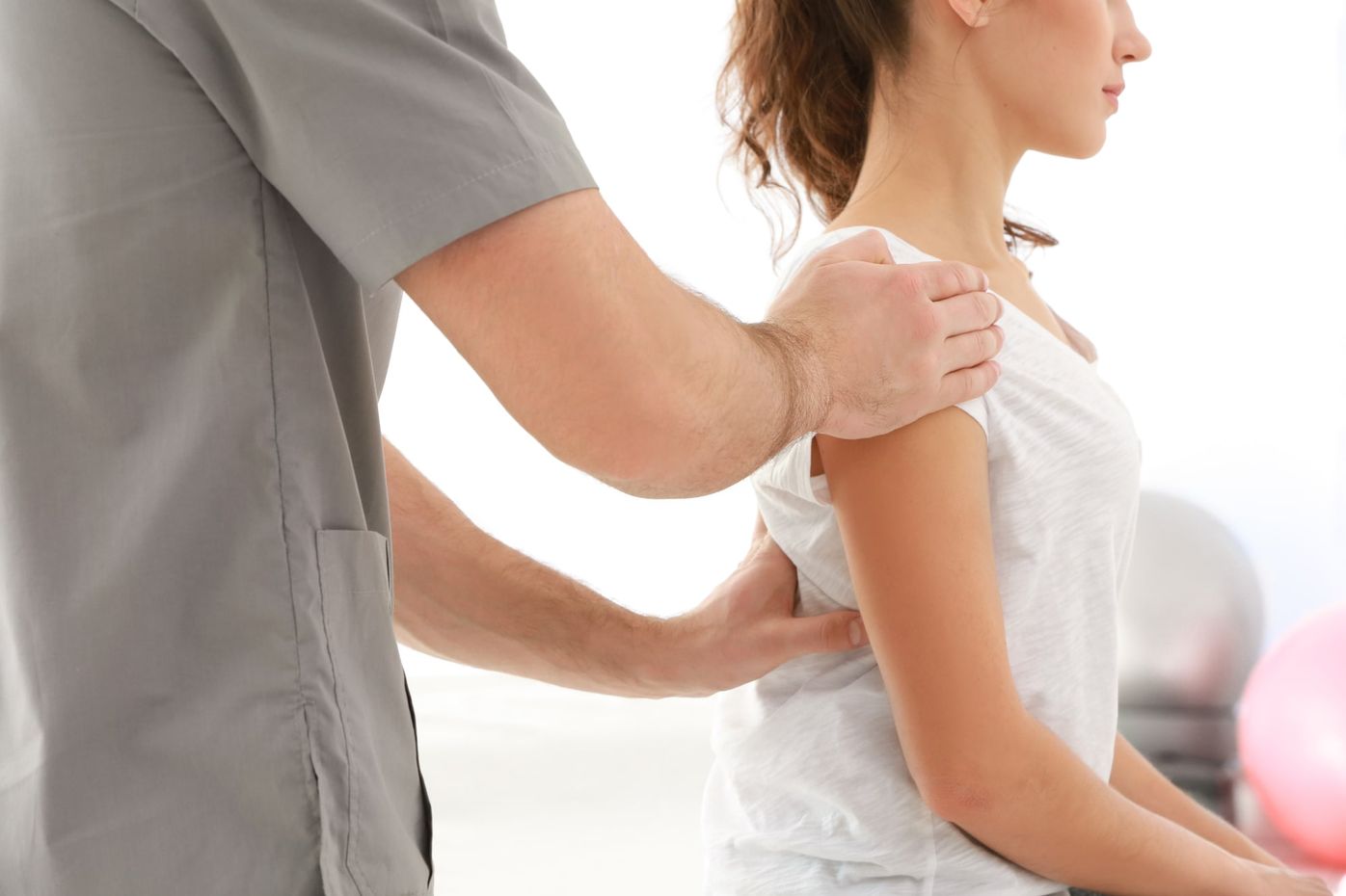 A chiropractor examining a patient&rsquo;s spine and posture by hand