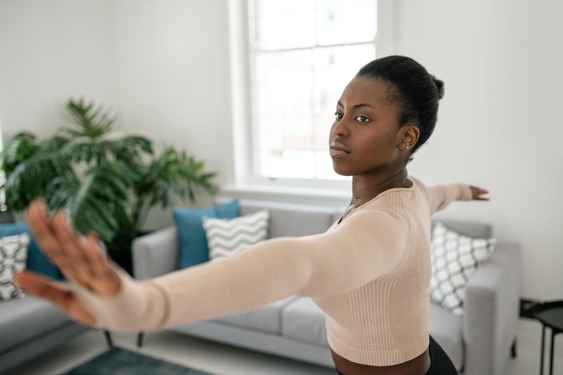 A person stretching comfortably at home, arms extended